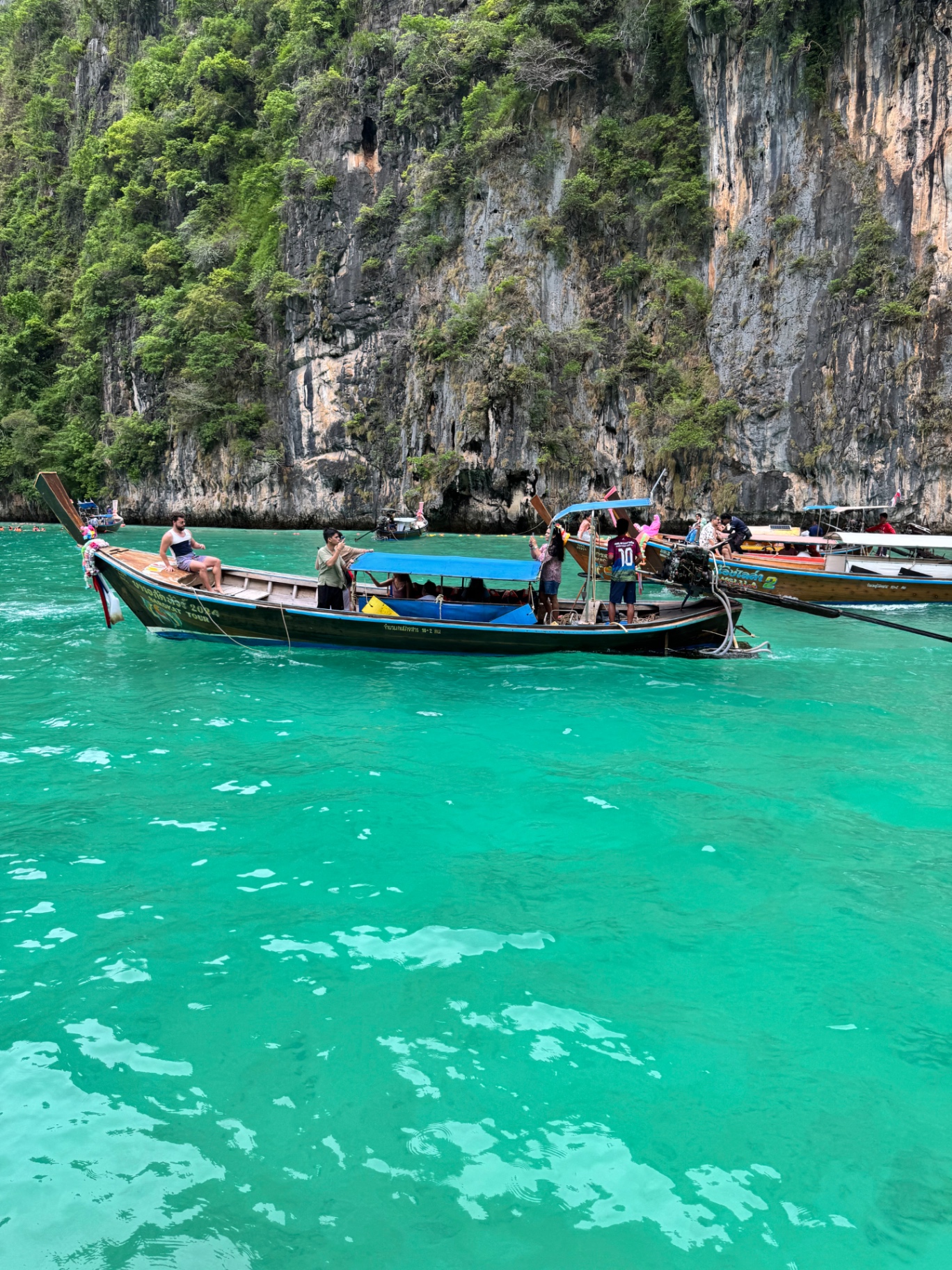 Traditional longtail boats in turquoise water at Phi Phi