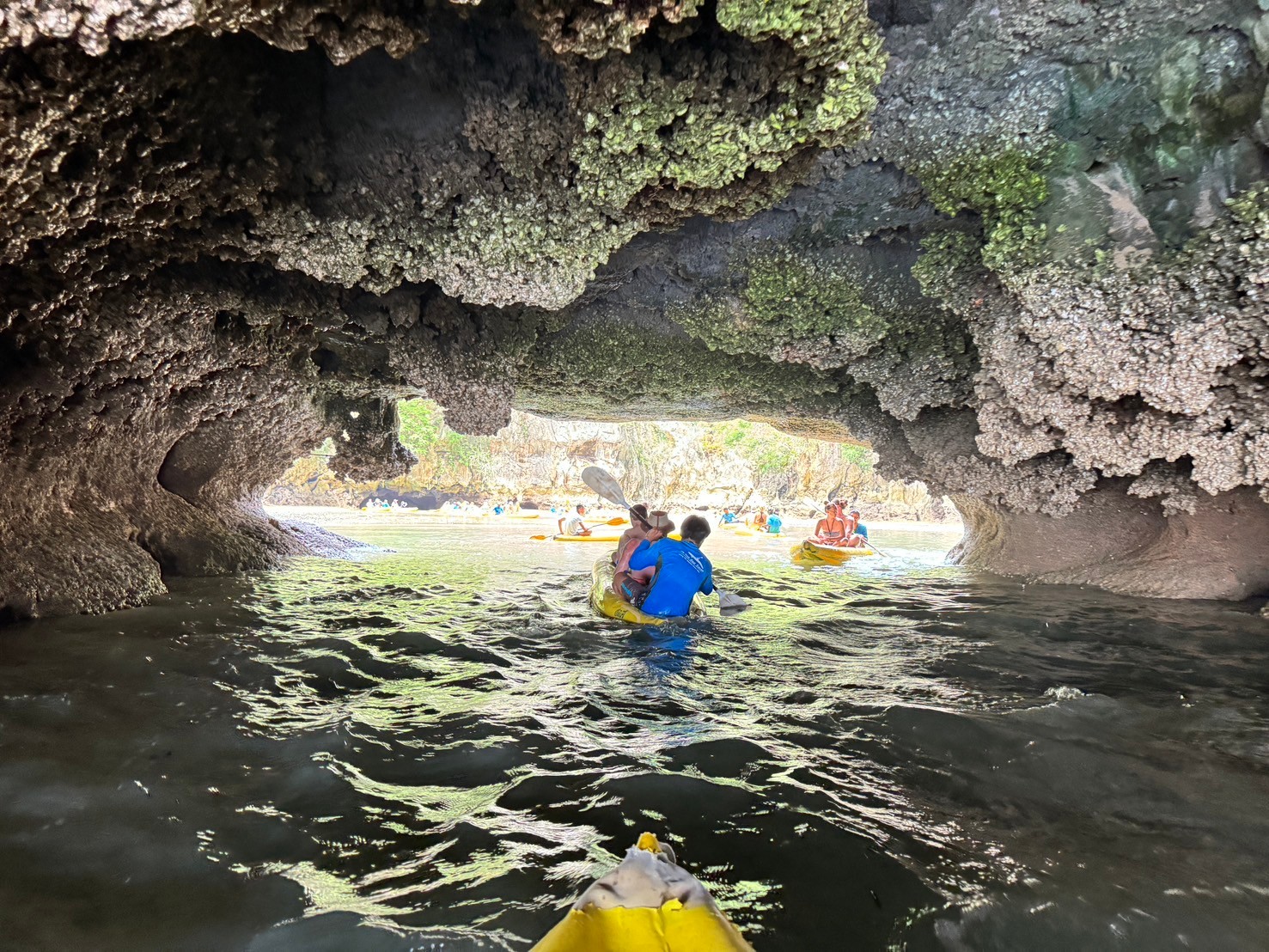 Paddling through a low sea cave into a hidden hong